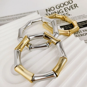 Bamboo style metal bangle set in gold and silver finish on white textured base