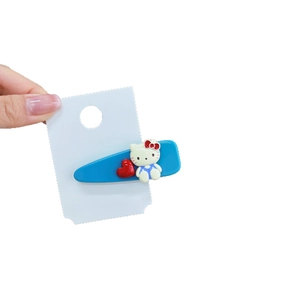 Blaue Acryl Hello Kitty Haarspange mit rotem Herzdesign auf weißer Karte