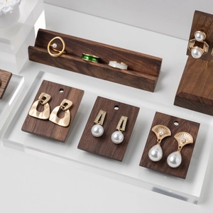 Walnut wood display rack with gold geometric earrings and pearl jewelry set