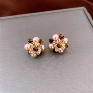 Vue détaillée de boucles d'oreilles fleur plaquées or avec perles et zircons