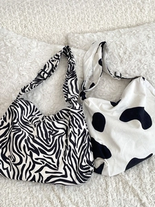 Large corduroy tote bags with black and white cow and zebra prints on plush rug