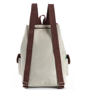 Detail view of the drawstring closure and adjustable straps on the beige canvas backpack