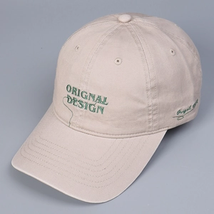 Close-up of the beige cotton baseball cap with green embroidery and six-panel structure