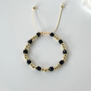 Detailed shot of black crystal beaded bracelet with 18k gold beads and adjustable cord