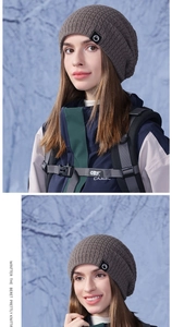 Gros plan du bonnet gris foncé en maille gaufrée avec écusson en cuir en extérieur hivernal