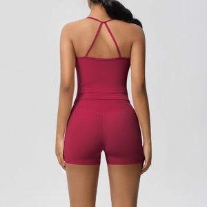 Detail of pink crisscross back yoga tank top and high-waisted shorts on model