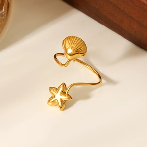 Macro detail of 18K gold starfish and shell starfish open ring with metallic luster