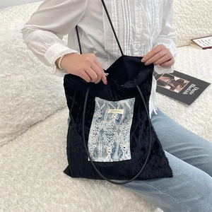 Vue détaillée du sac cabas en velours noir avec broderie dentelle et fines lanières