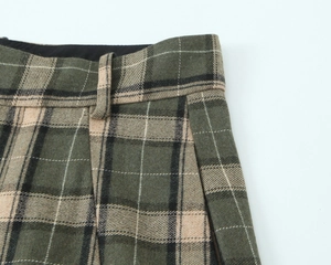 Détail du pantalon à carreaux montrant la texture du tissu, les poches et passants