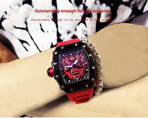 Detail of red and black tonneau sports watch with silicone strap on male wrist