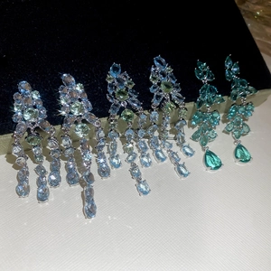 Makroaufnahme von blattförmigen Silberohrringen mit blauen und grünen Zirkonanhängern