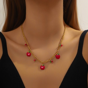 Golden chain necklace with 3D red apple charms on female model wearing black top