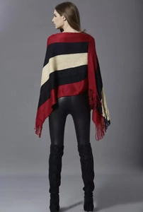 Detail view of colorful knitted stripe pattern and fringe trim on the women's poncho