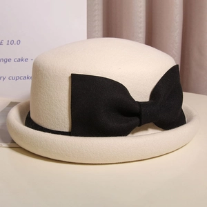 Elegant French wool beret hat in cream white featuring a large black contrast bow accent