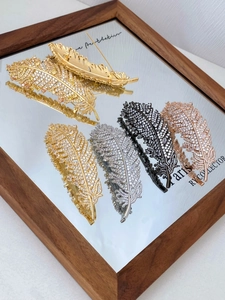Detailed view of feather brooches with micro-pave zircons in four metallic colors