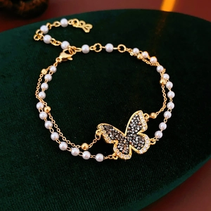 Macro shot of double-layered butterfly pearl bracelet with gold plating and crystals