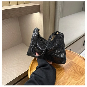 Détail du tissu à paillettes noires et des finitions dorées sur ce sac à main femme