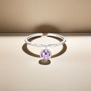 Close-up of S925 hallmark on silver ring with dangling faceted purple gemstone