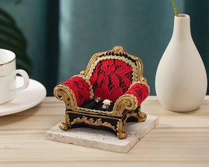 Close-up of European retro red lace sofa jewelry display stand with golden relief carving