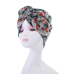 Detail of bohemian turban hat featuring a classic paisley print and front twist design