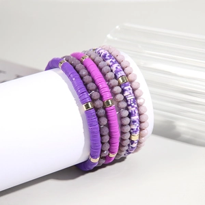 Bohemian purple beaded bracelet set with clay discs and crystal beads on a display