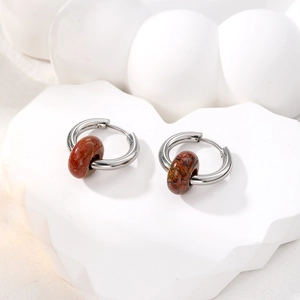Detailed shot of silver stainless steel hoop earrings with reddish brown marble beads