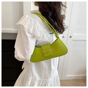 Close-up of avocado green leather shoulder bag featuring golden metallic trim detail