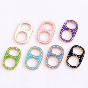 Detailed view of colorful soda tab jewelry charms with gold metal bases and shell inlay