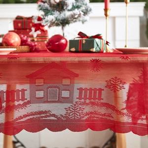 Red rectangular Christmas lace tablecloth featuring snowy house and fence patterns