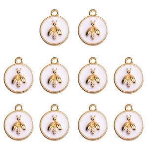 Detailed view of ten white enamel bee charms with gold plated alloy edges and rings
