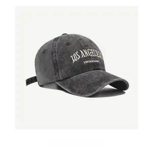 Detail of embroidered Los Angeles logo on vintage washed grey denim baseball cap