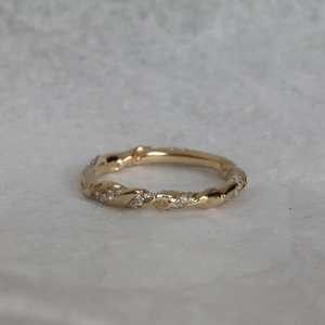 Macro detail of a 18K gold-plated twisted ring featuring colorful sparkling zircon stones