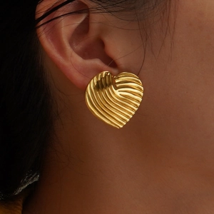 French style gold heart earrings with pleated texture shown on model for elegant look
