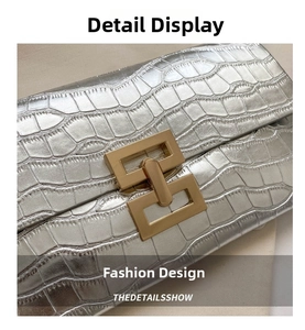 Detail of silver crocodile embossed leather texture with elegant gold rectangle buckle