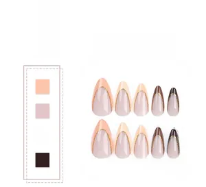 Detail of almond-shaped press-on nails with brown French tips and gold glitter accents