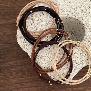 Elastic beaded hair ties in neutral tones featuring elegant golden decorative beads