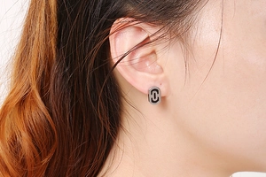 Close-up of a silver geometric paperclip earring on a model for a modern look