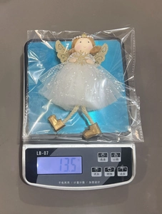Detailed view of angel ornament weighing 13.5g with white mesh and gold wings