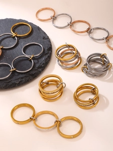 Detail of interlocking tricolor stainless steel rings with zircon stones in gold and rose gold