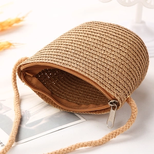 Detail der natürlichen Strohtextur und des silbernen Reißverschlusses dieser Mini-Tasche