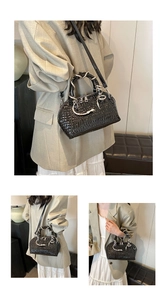 Detail view of black crocodile pattern shell bag with unique silver snake-shaped handle