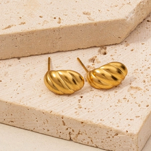 Detailed shot of vintage gold croissant earrings with textured metal finish on stone