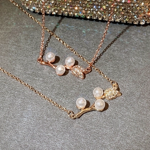 Detailed close-up of rose gold pearl necklace featuring zircon-encrusted leaf accents