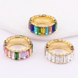 Rainbow and white baguette cut zircon rings in gold plating on marble base
