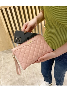 Pink quilted clutch bag with golden zipper showing interior capacity for a smartphone