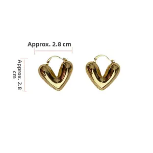 Vista detallada de pendientes de corazón dorado mostrando medidas de unos 2,8 cm