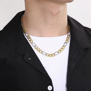 Gros plan d'un collier chaîne Figaro bicolore or et argent porté par un mannequin