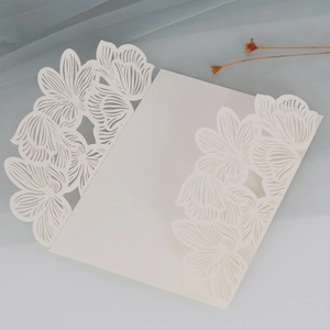 Macro view of laser-cut rose hollow pattern on ivory white wedding invitation cover