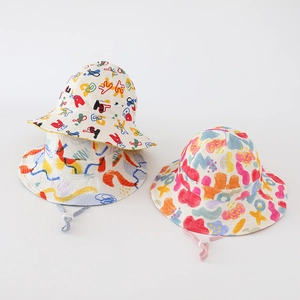 Detail of reversible kids bucket hat featuring colorful graffiti patterns and adjustable chin strap