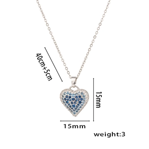 Detail view of heart pendant size 15mm by 15mm with blue gems on silver chain